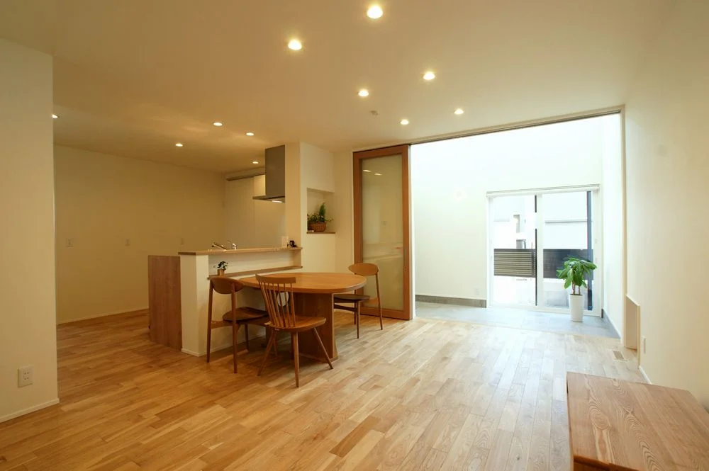 玄関土間からリビングと庭へつながる住宅の内観